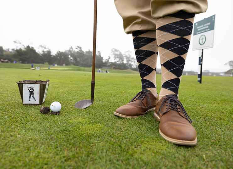 Golfer's legs with club and golf ball.